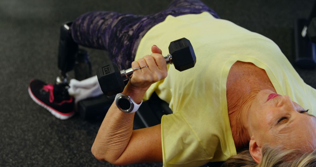 Senior Woman with Prosthetic Leg Lifting Dumbbell in Gym - Free Images, Stock Photos and Pictures on Pikwizard.com