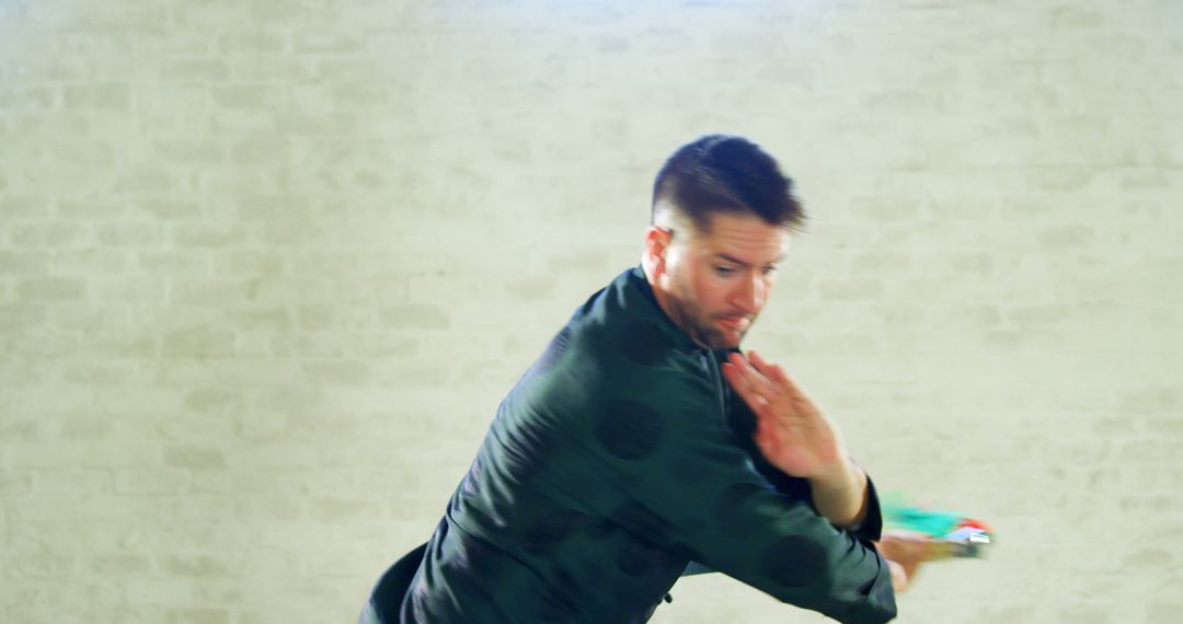 Man Practicing Karate in Front of White Brick Wall - Free Images, Stock Photos and Pictures on Pikwizard.com