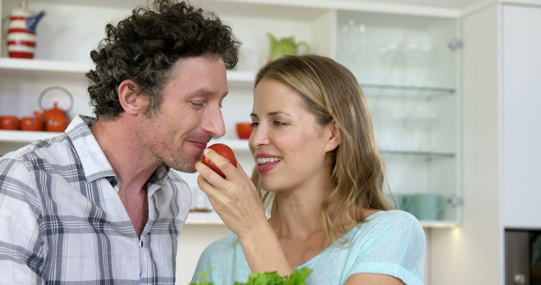 Smiling couple holding tomato in the kitchen - Free Images, Stock Photos and Pictures on Pikwizard.com