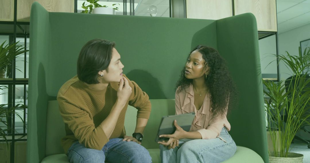 Colleagues Collaborating in Modern Office Lounge With Tablet