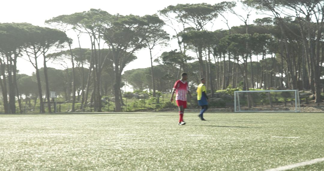 Soccer players in red uniforms practicing on sunny field