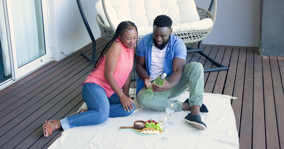 Couple Enjoys Wine and Snacks Together on Apartment Balcony