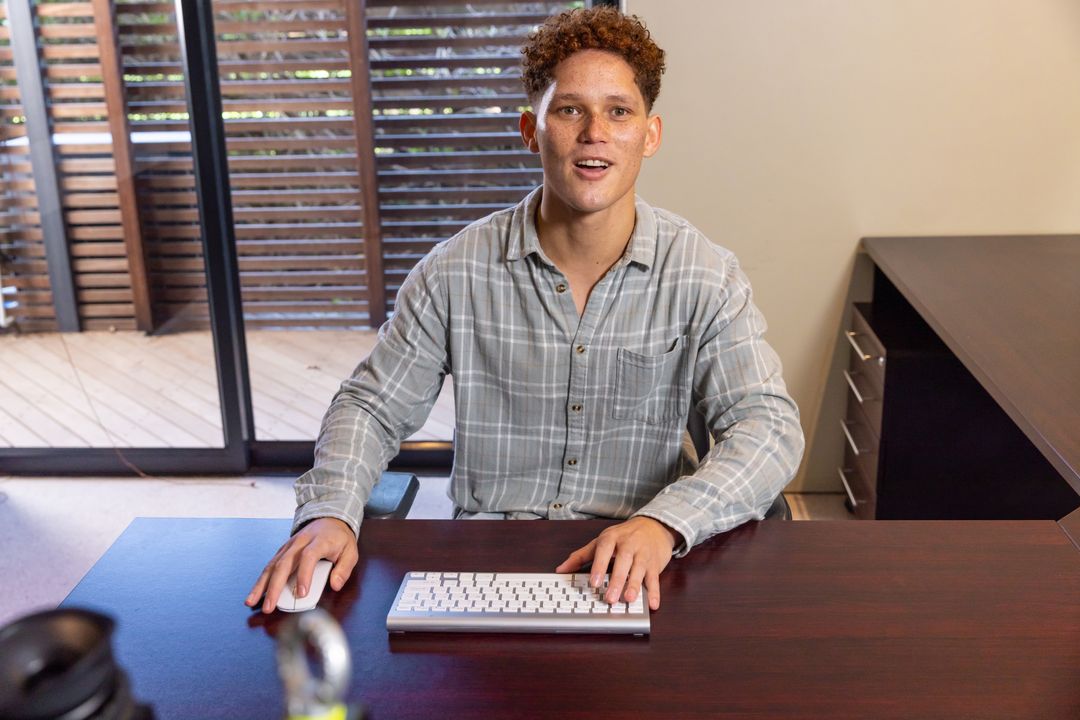 Man Working at Home Office Desk by Sliding Glass Doors