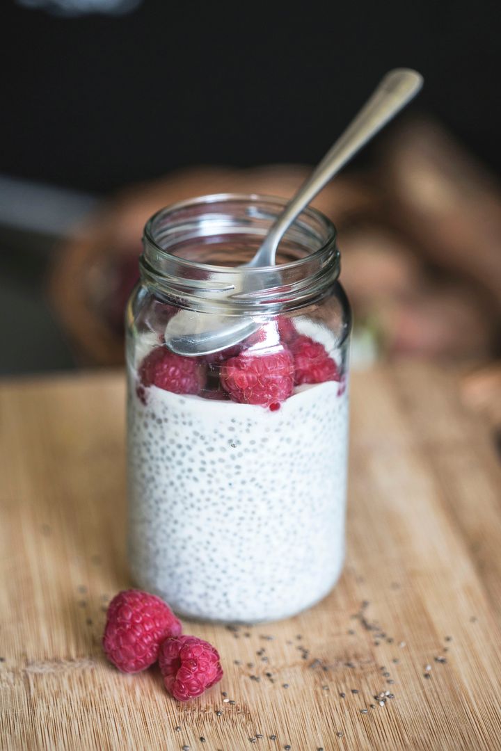Chia Pudding Jar with Fresh Raspberries on Wooden Surface