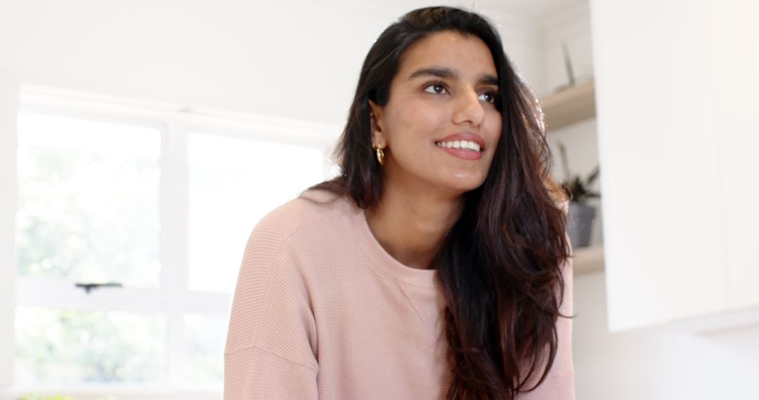 Smiling Woman Leaning on Counter in Bright Kitchen