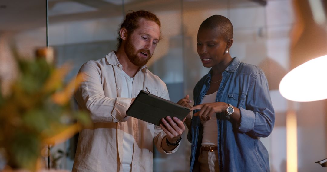Diverse Business Team Collaborating on Tablet in Evening Meeting