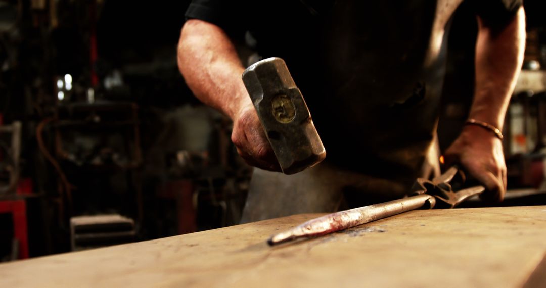 Skilled Blacksmith Forging Metal in Industrial Workshop