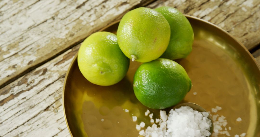 Green Lemon Limes on Gold Tray with Coarse Sea Salt on Rustic Wooden Table - Free Images, Stock Photos and Pictures on Pikwizard.com