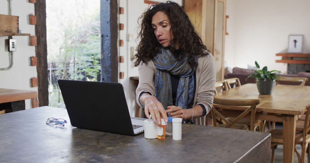 Middle-aged woman managing medication while using laptop - Free Images, Stock Photos and Pictures on Pikwizard.com