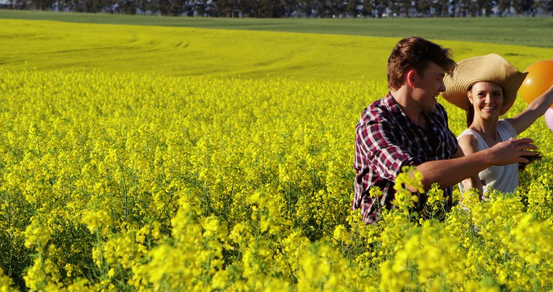 Couple enjoying a sunny day in a blooming canola field - Free Images, Stock Photos and Pictures on Pikwizard.com