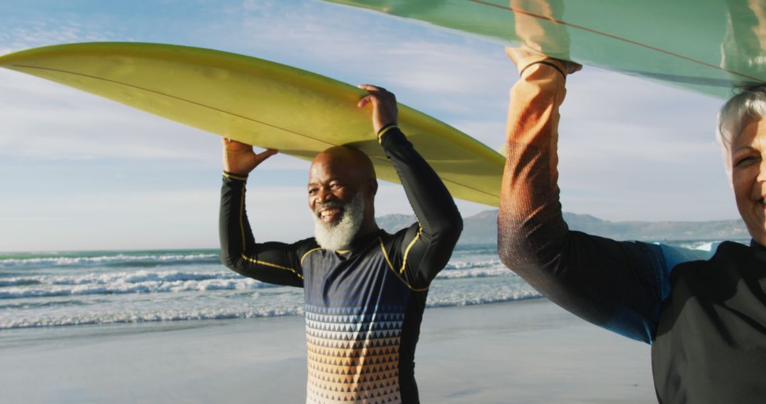 Senior Surfers Carrying Surfboards at Beach - Free Images, Stock Photos and Pictures on Pikwizard.com