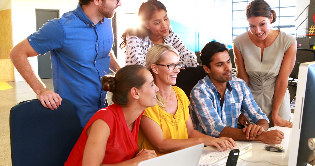 Diverse Team Collaborating on Project Near Office Desk