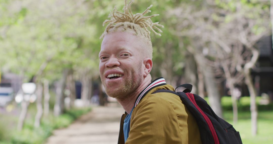 Smiling African American Albino Man with Dreadlocks in Urban Park