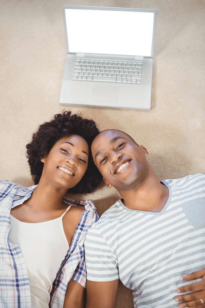 Cheerful Couple Relaxing with Laptop on Floor Smiling