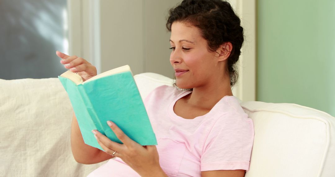 Pregnant Woman Enjoying Reading Book on Couch at Home - Free Images, Stock Photos and Pictures on Pikwizard.com