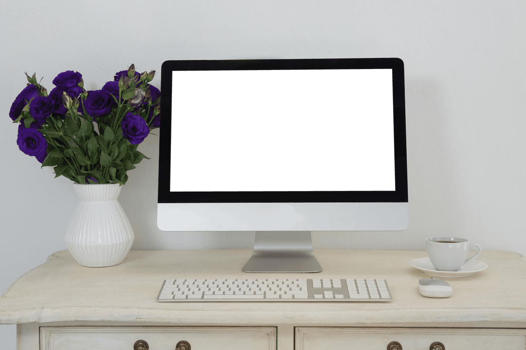 minimalistic office desk with empty computer screen and vase of flowers