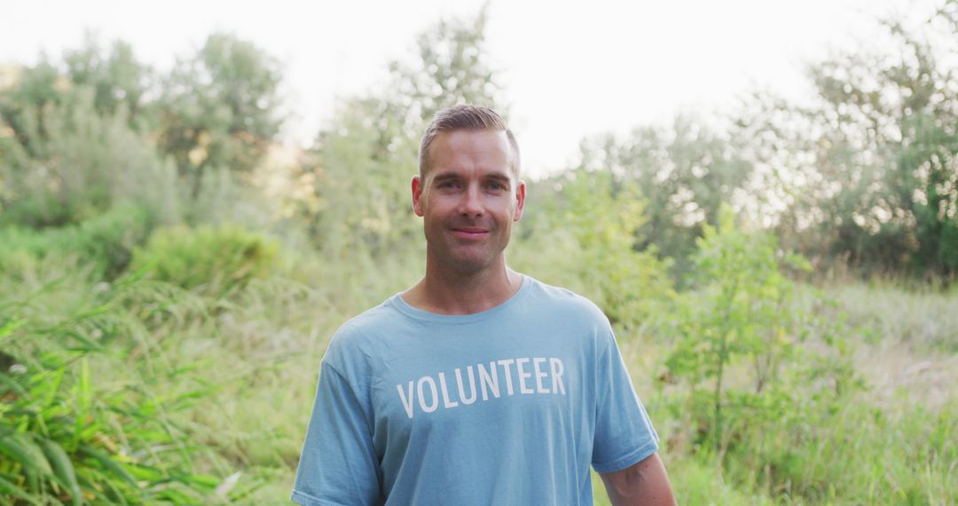 Male Volunteer in Blue Shirt Smiling in Green Nature Reserve - Free Images, Stock Photos and Pictures on Pikwizard.com