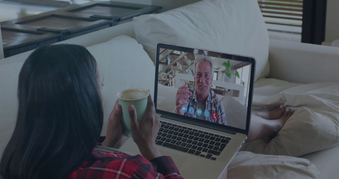 Woman Holding Coffee Enjoying Virtual Video Call from Couch
