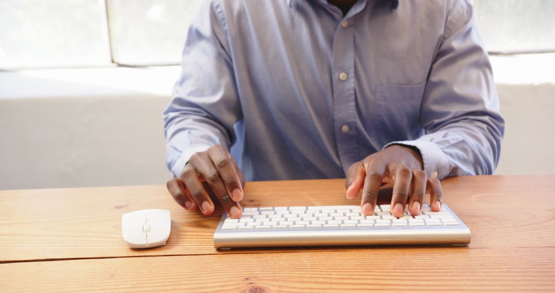 Man Typing on Keyboard in Bright Office Workspace