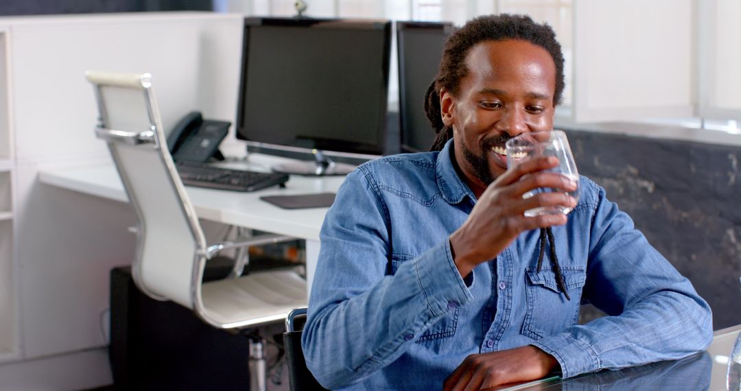 Professional Man Enjoying Refreshing Water Break at Office Desk