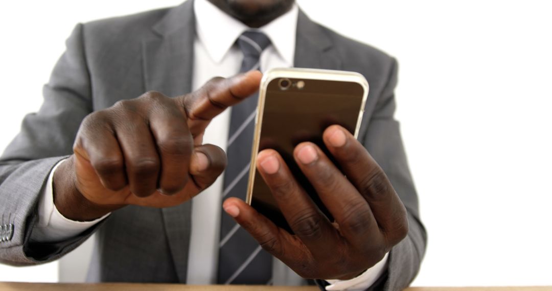 African American businessman in a suit is using a smartphone, with copy space - Free Images, Stock Photos and Pictures on Pikwizard.com