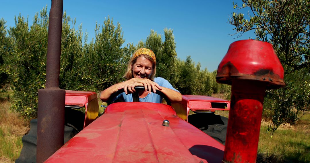 Happy Woman Farmer Operating Red Tractor in Olive Grove - Free Images, Stock Photos and Pictures on Pikwizard.com