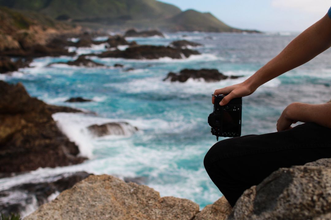 Photographer Capturing Ocean Scenery on Rocky Coast - Free Images, Stock Photos and Pictures on Pikwizard.com
