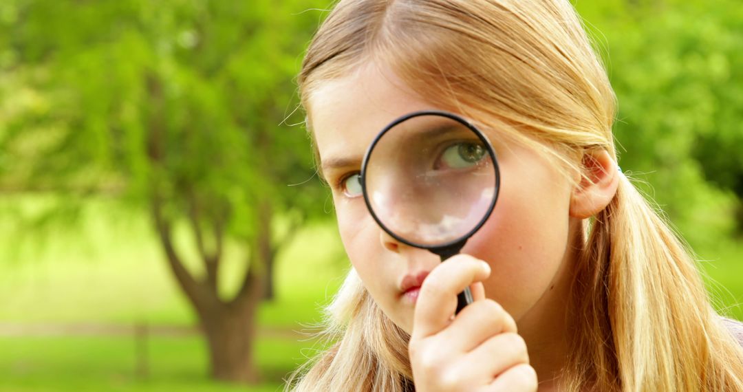 Curious Young Girl Exploring Nature with Magnifying Glass in Park - Free Images, Stock Photos and Pictures on Pikwizard.com