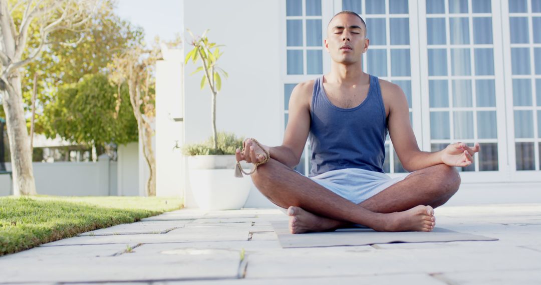 Focused Man Meditating Outdoors in Sunny Garden Setting - Free Images, Stock Photos and Pictures on Pikwizard.com