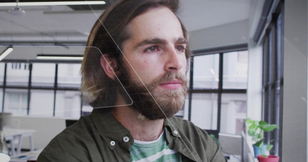 Bearded Man Focused on Technology in Modern Open-Office Space