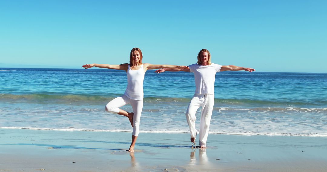 Couple performing yoga at beach on a sunny day 4k - Free Images, Stock Photos and Pictures on Pikwizard.com