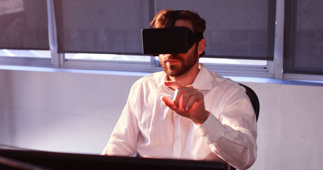 Businessman using virtual reality headset in office setup - Free Images, Stock Photos and Pictures on Pikwizard.com