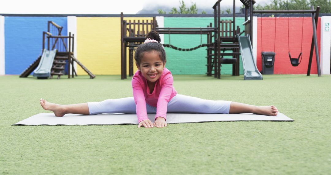 Young Girl Practicing Splits in Colorful Playground with Joyous Spirit