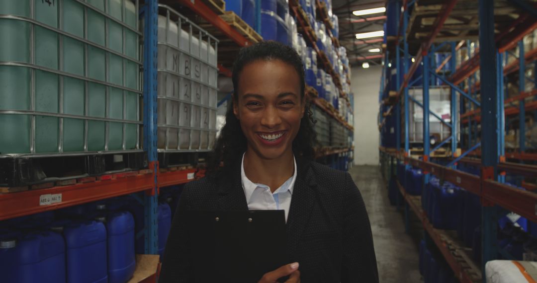 Smiling Warehousing Worker Inspecting Inventory in Industrial Storage Facility - Free Images, Stock Photos and Pictures on Pikwizard.com