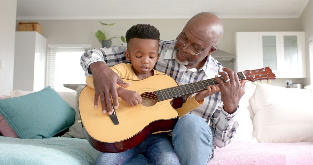 Grandfather Teaching Young Boy How to Play Guitar at Home - Free Images, Stock Photos and Pictures on Pikwizard.com