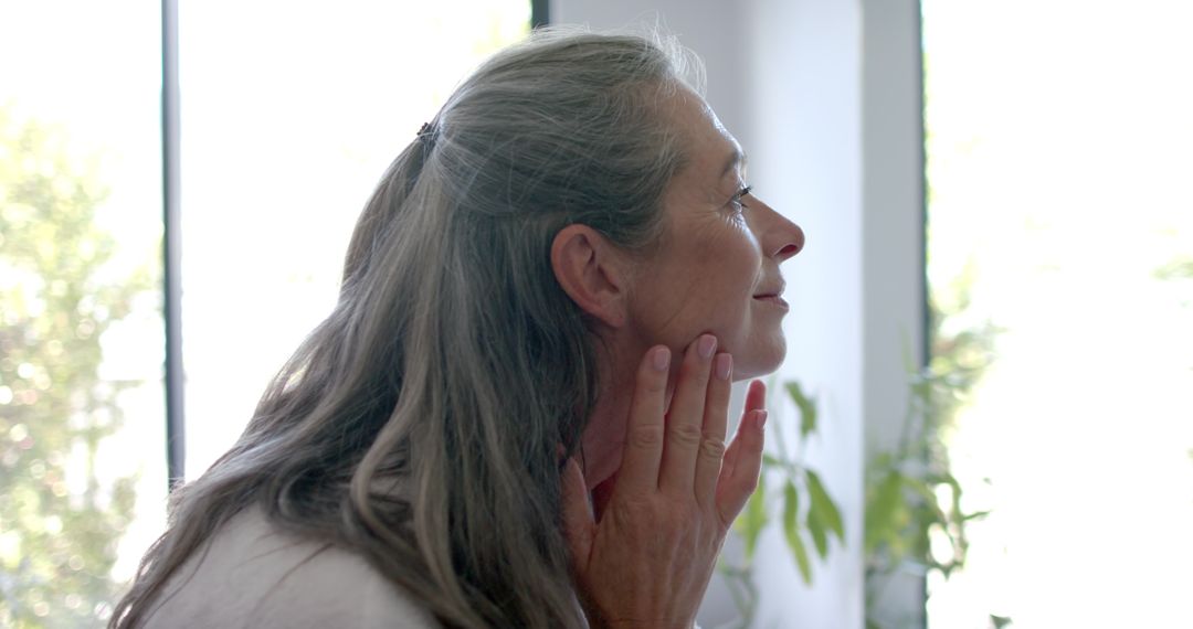 Mature Woman Touching Face In Thoughtful Quiet Reflection