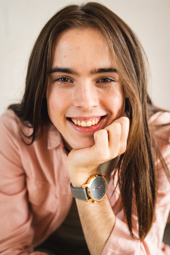 Close up portrait of non-binary trans woman with hand on chin smiling at home - Free Images, Stock Photos and Pictures on Pikwizard.com