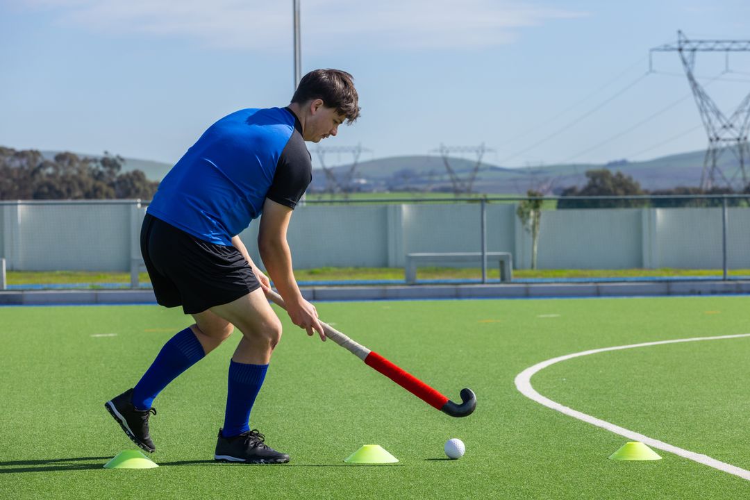 Young Field Hockey Player Practicing Dribbling Skills on Turf Field
