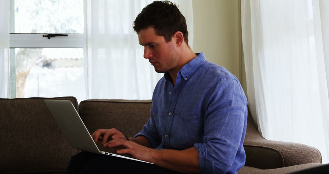 Focused Man Working on Laptop at Home, Daytime - Free Images, Stock Photos and Pictures on Pikwizard.com