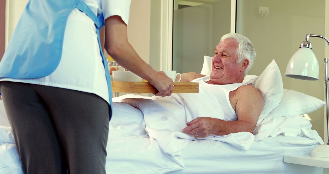 Elderly Man Receiving Breakfast from Nurse in Hospital Bed - Free Images, Stock Photos and Pictures on Pikwizard.com