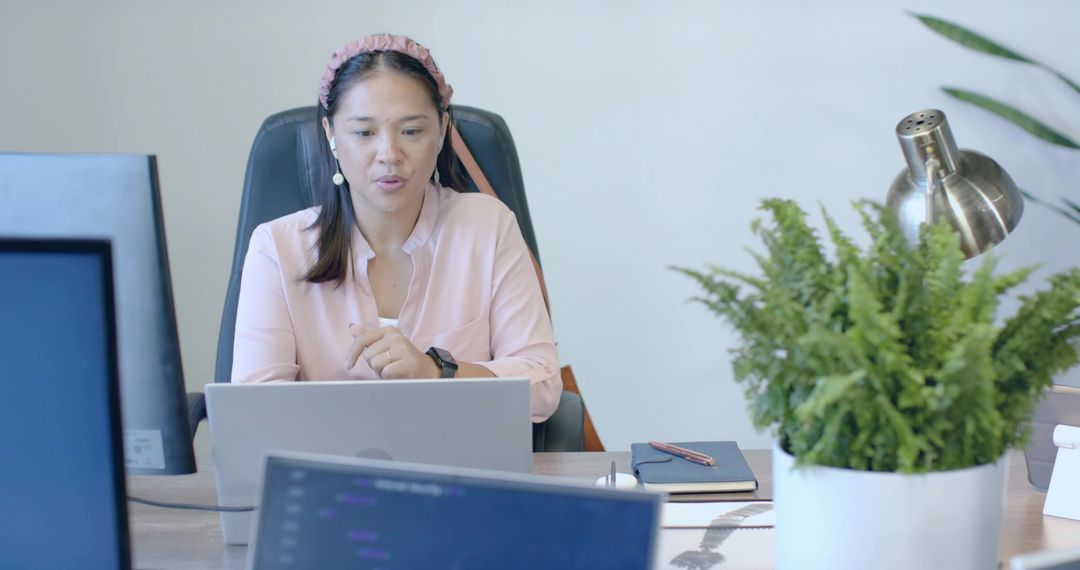 Female Professional Leading Virtual Meeting from Office Desk
