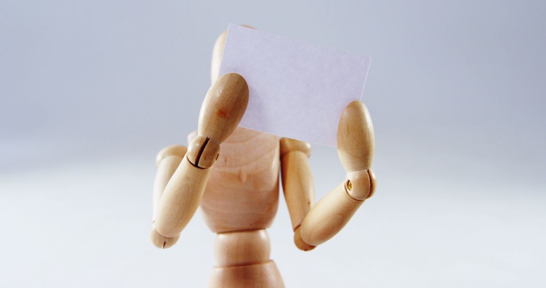 Wooden Mannequin Holding Blank Paper Card - Free Images, Stock Photos and Pictures on Pikwizard.com