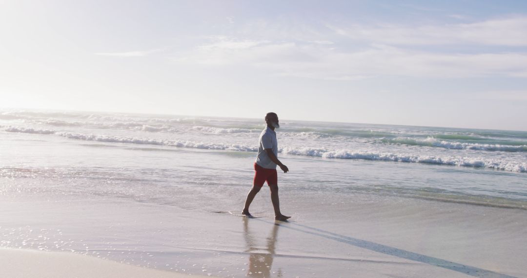 Senior african american man walking at the beach - Free Images, Stock Photos and Pictures on Pikwizard.com