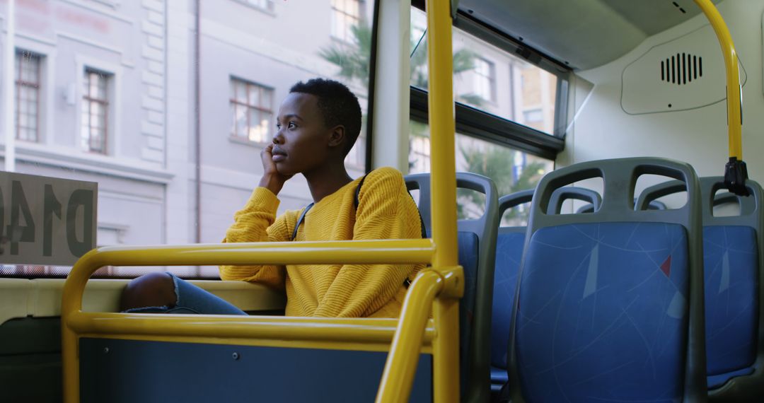 Young Person in Yellow Sweater Contemplating While Riding Empty Bus - Free Images, Stock Photos and Pictures on Pikwizard.com