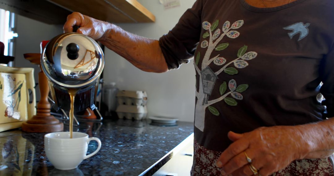 Senior Woman Pouring Coffee in Kitchen - Free Images, Stock Photos and Pictures on Pikwizard.com