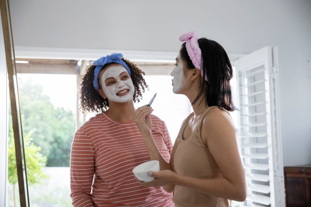 Diverse Female Friends Applying Face Masks Enjoying Skincare Routine