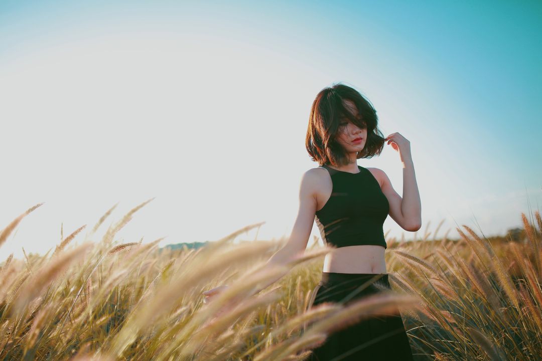 Woman in Black Top Standing in Sunny Wheat Field - Free Images, Stock Photos and Pictures on Pikwizard.com