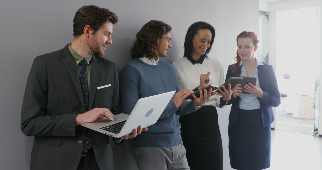 Diverse Business Team Collaborating with Devices in Modern Office