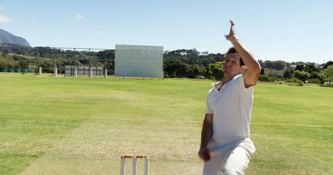 Cricket Bowler Delivering Ball on Field Under Bright Sky - Free Images, Stock Photos and Pictures on Pikwizard.com