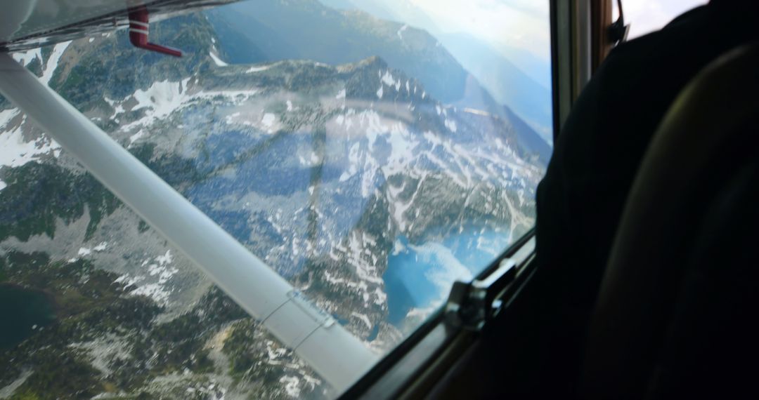 Aerial View from Aircraft Window Over Mountainous Lakes Area